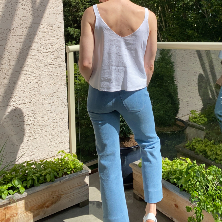 white modified Ogden cami and wide leg, light wash ginger jeans, back view