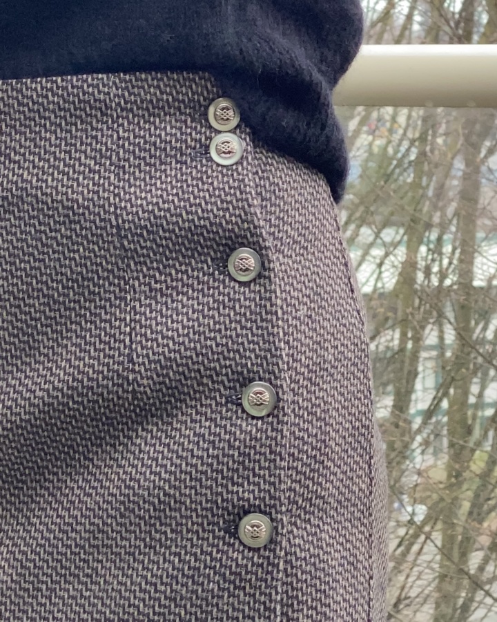 Close up view of the wool skirt fabric and five buttons